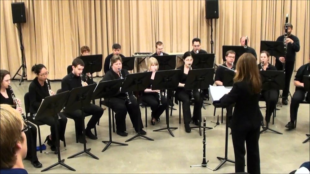 The Clarinet Choir performing in a rehearsal hall in front of a pale curtain