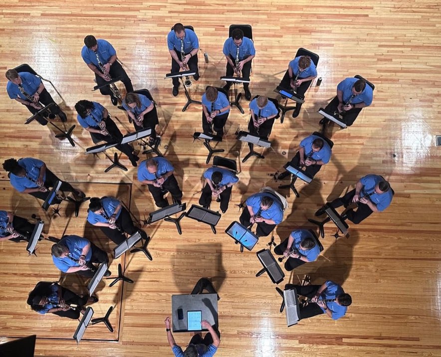 The Clarinet Choir seen from above, seated in a wide arc on a wooden floor