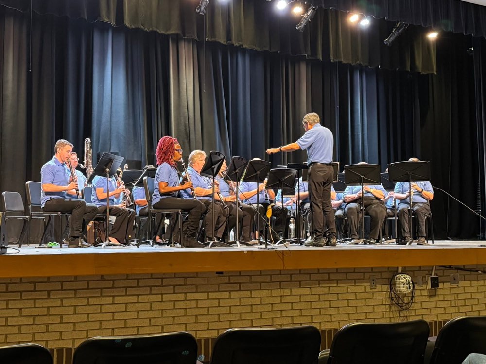 The Clarinet Choir performing on a school stage, conducted from the front