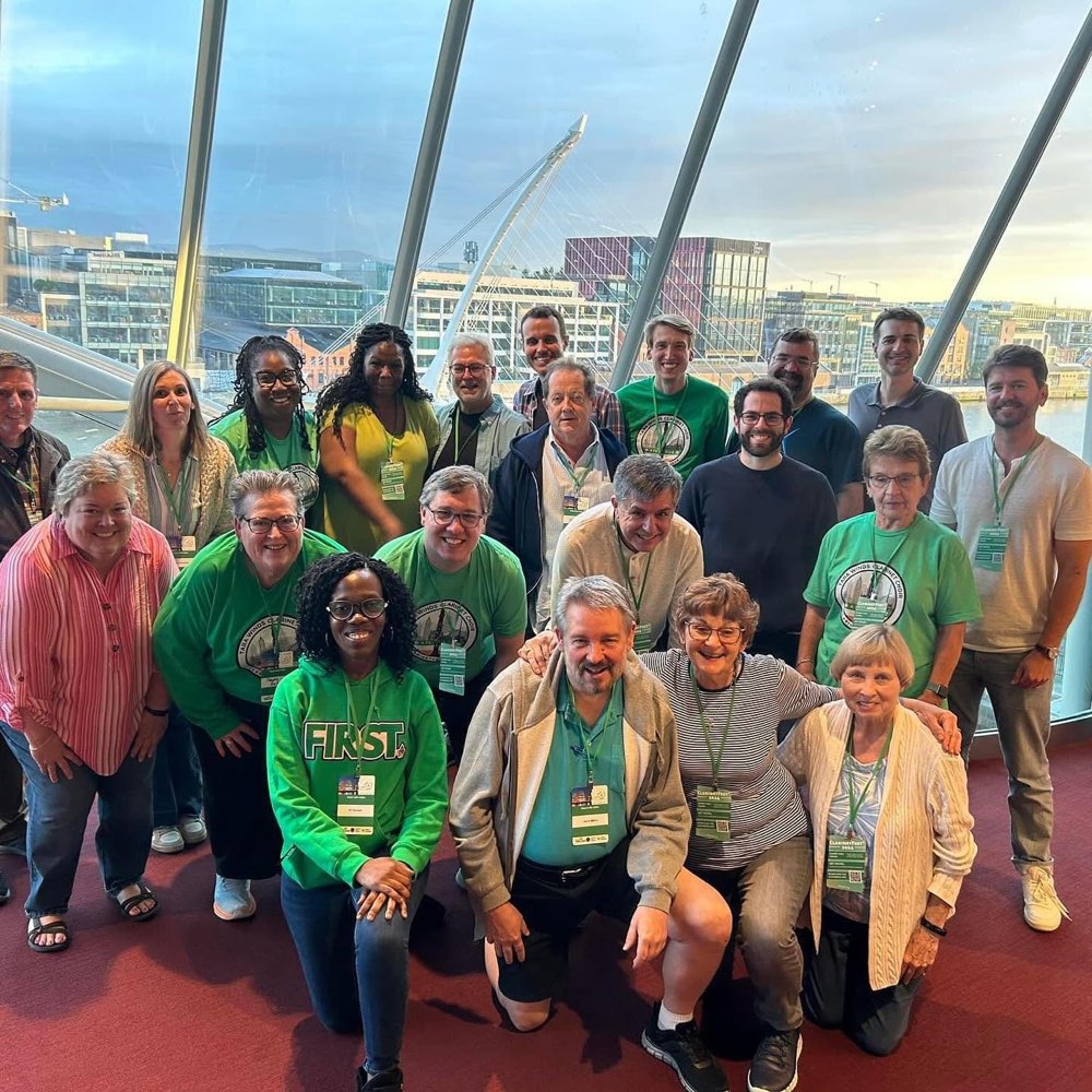 The Clarinet Choir posed together in green festival shirts, the River Liffey behind them